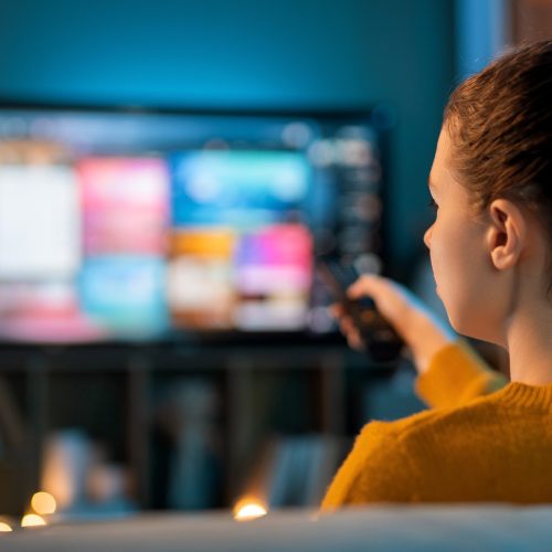 Young woman watching TV at home.